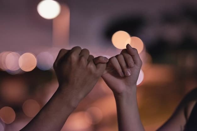 A close-up of two hands clasped together in a sign of unity and support, with a diverse group of people blurred in the background. The lighting is soft and warm, emphasizing connection and solidarity.