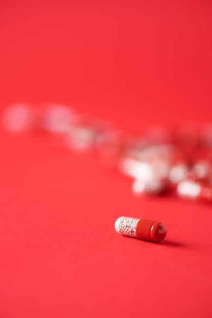 A close-up of a prescription bottle with pills spilling out. The background is blurred but suggests a pharmacy setting. The image emphasizes the high cost of prescription medications.