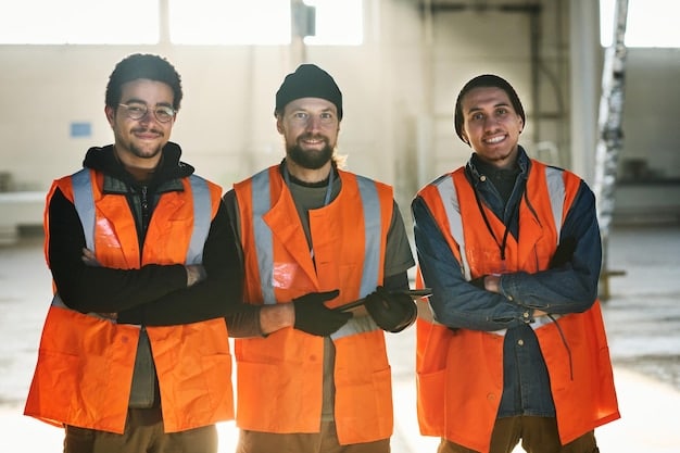 A group of diverse workers in a factory, wearing safety gear and working together. The scene shows a variety of tasks being performed, emphasizing the importance of immigrant labor in the U.S.