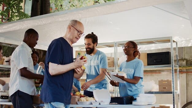 Volunteers setting up booths at a community health fair, with tables covered in informational pamphlets and health-related giveaway items. They are smiling and working together efficiently.
