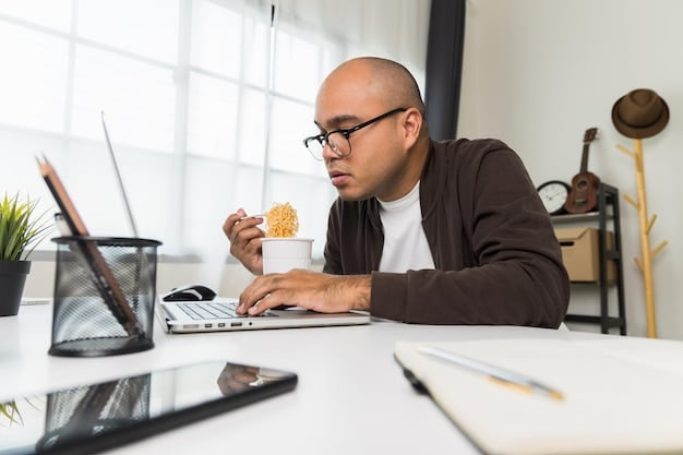 A person sitting at a desk, using a laptop to research grant opportunities. The focus is on the laptop screen, which displays a grant application website. The setting is a home office, suggesting dedication and focused effort.