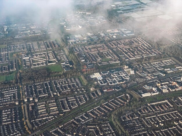 An aerial view of a densely polluted urban area with factories emitting smoke and smog covering the city. This image highlights the impact of industrial pollution on urban communities and its relevance to Environmental Health: Protecting Communities from Environmental Hazards Through Public Health Initiatives.