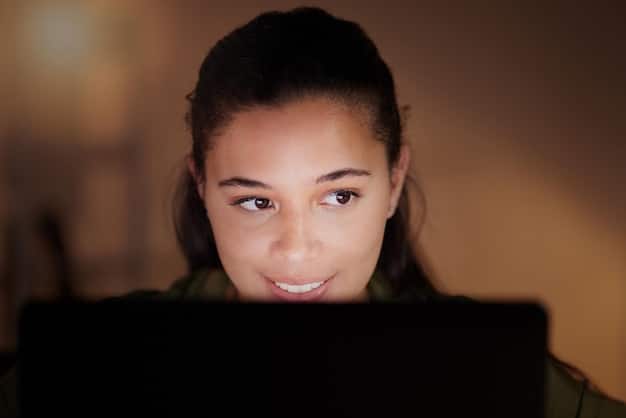 A close-up image of a person's face illuminated by the glow of a laptop screen, with a reflection showing a mob of angry faces on the screen, symbolizing the intense scrutiny and potential for online harassment associated with cancel culture. 